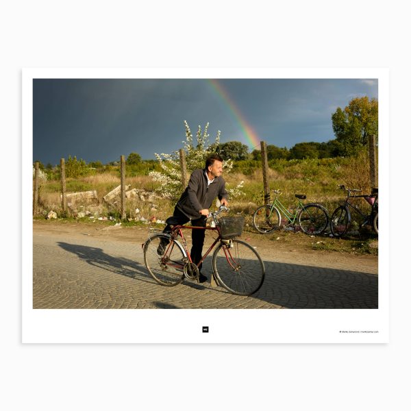 A man sits on his bicycle, ready to head home after a long day, but the dark clouds on the horizon are a warning that he might not make it in time. Šabac, Serbia, 2013.