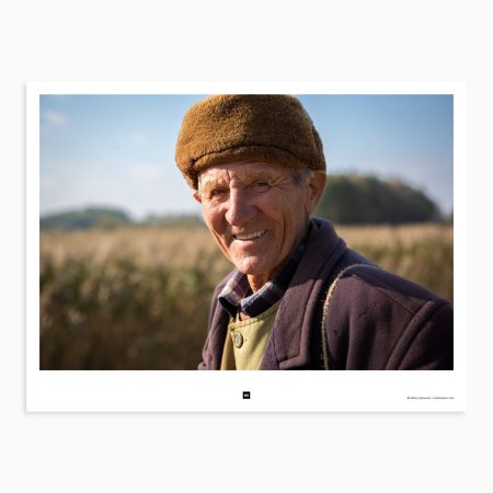 Portrait of an old shepherd. His gaze is direct and steady, revealing a lifetime of hard-earned wisdom and a deep connection to the land. He holds a gentle, trusting relationship with his animals, and a strong sense of stewardship for the land he calls home. Radenković, Serbia, 2014.